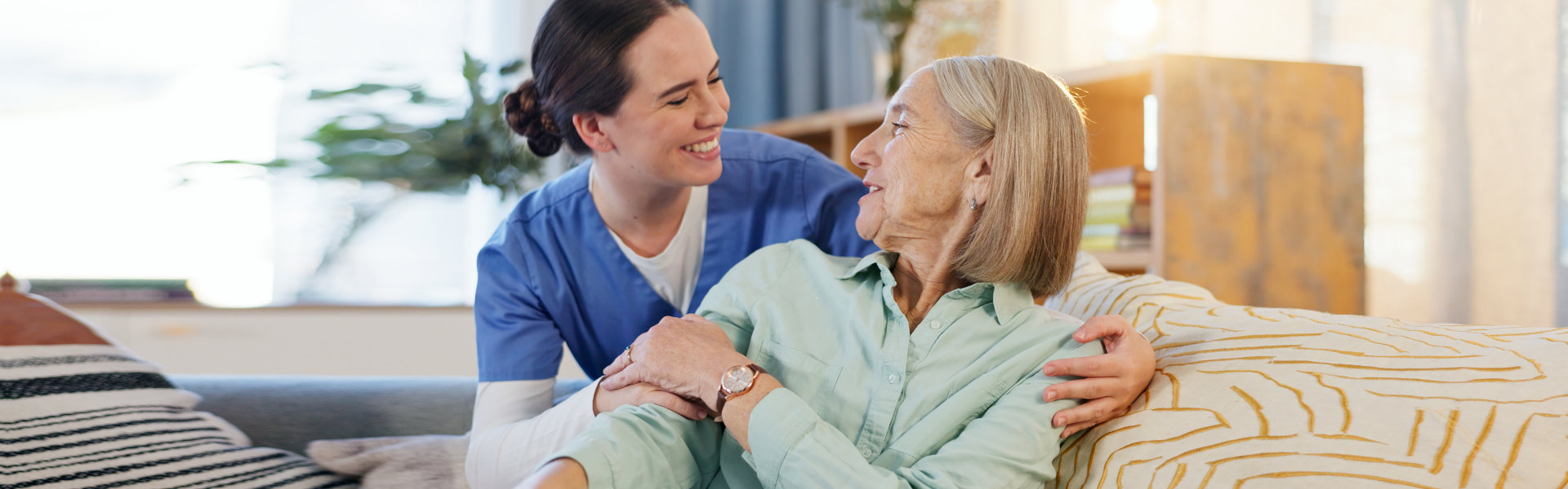 Caring Woman Embracing Senior at Home